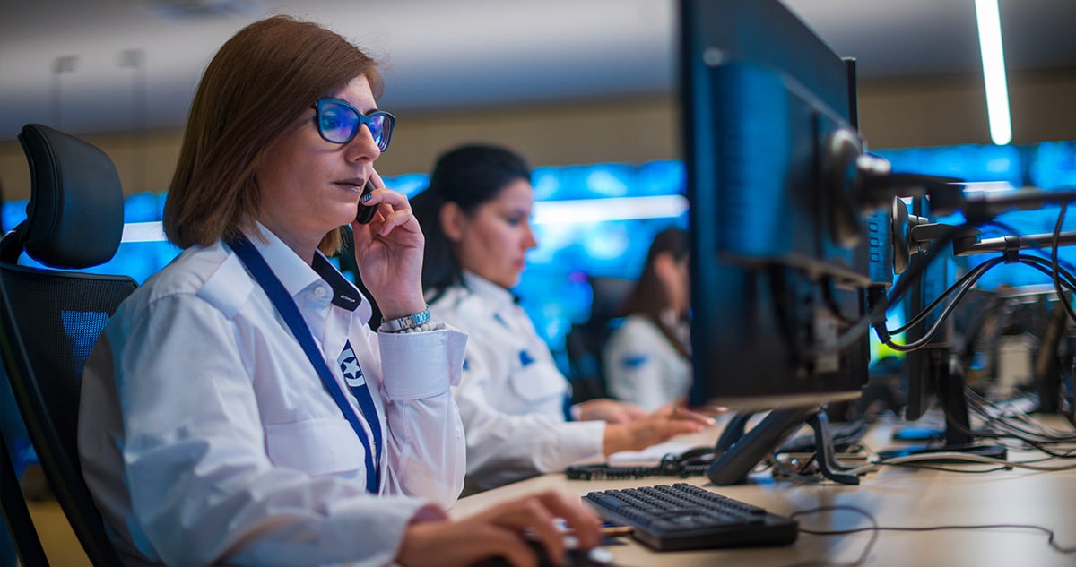 People looking at tablet. Tablet is enlarged to show commercial security solutions