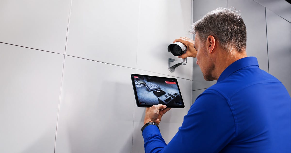 People looking at tablet. Tablet is enlarged to show commercial security solutions